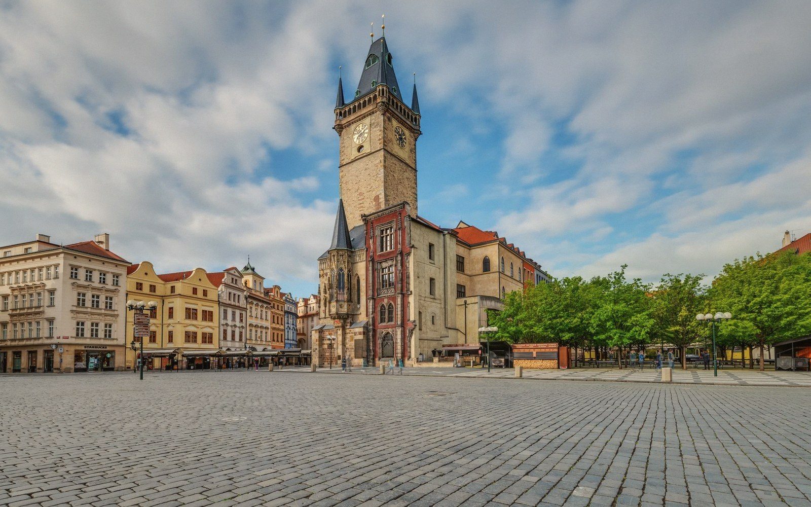 Period photograph of Prague's Old Town Square looking toward the Týn Church, cobblestones wet, few pedestrians, overcast sky